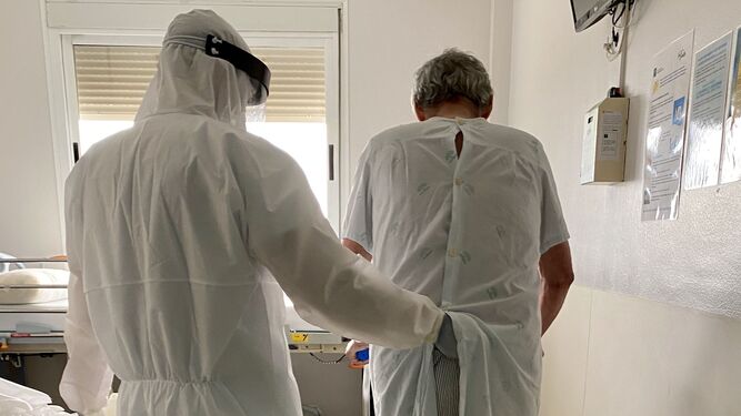Paciente Covid recibiendo atención por parte de un fisioterapeuta en su habitación de la planta de hospitalización del Hospital de Valme.