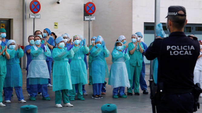 Trabajadores sanitarios y personal del Hospital Universitario Reina Sofía de Córdoba agradecen los aplausos de la Policía Local.