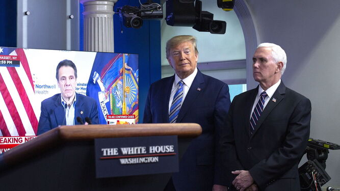 Donald Trump, junto al vicepresidente Mike Pence, mientras una cadena televisiva emite la rueda de prensa del gobernador de Nueva York, Andrew Cuomo.