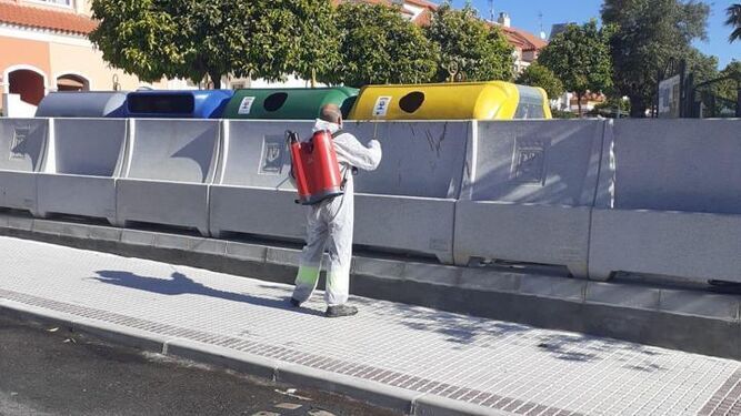 Un operario desinfecta contedores de residuos sólidos urbanos en Castilleja de la Cuesta.