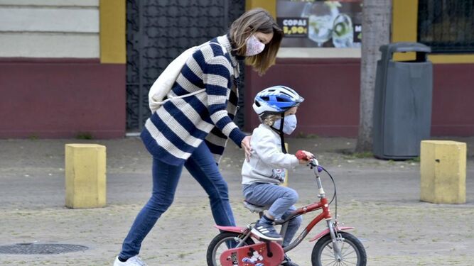Un niño pasea con su bicicleta este domingo