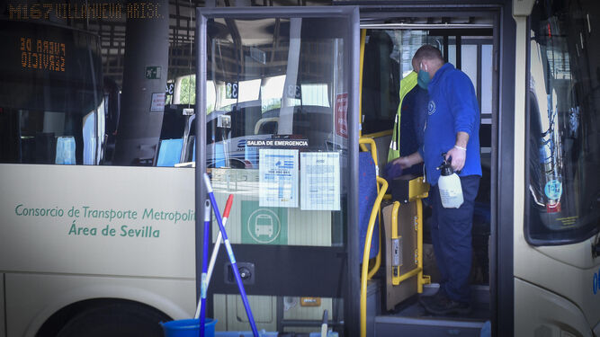 Un operario limpia un autobús del Consorcio de Transporte Metropolitano antes de subirse los usuarios.