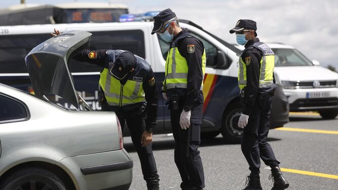 Policías nacionales, este viernes, revisando un vehículo en la salida de Sevilla por la A-49.