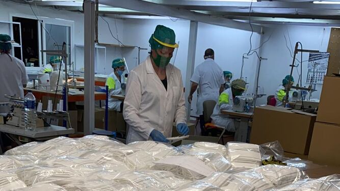 Operarios trabajando en la producción de mascarillas quirúrgicas del tipo IIR.