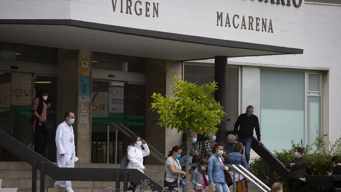 Pacientes y sanitarios en la escalera de acceso al Hospital Virgen Macarena.