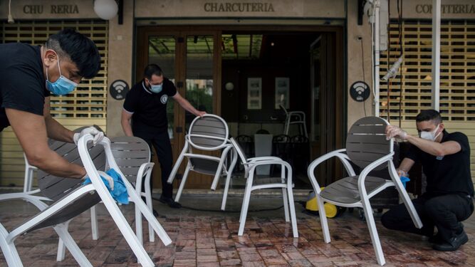 Trabajadores de un bar de Málaga preparan el mobiliario por si pasan a la fase 1.