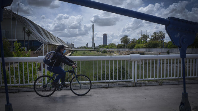 Una ciclista atraviesa un puente sobre el canal de la Expo.