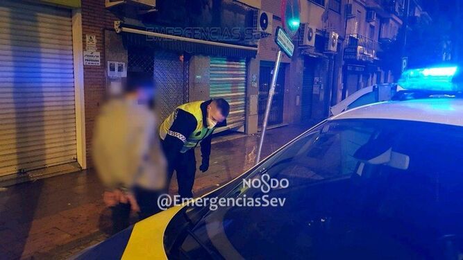 Un policía local de Sevilla custodia al menor detenido.