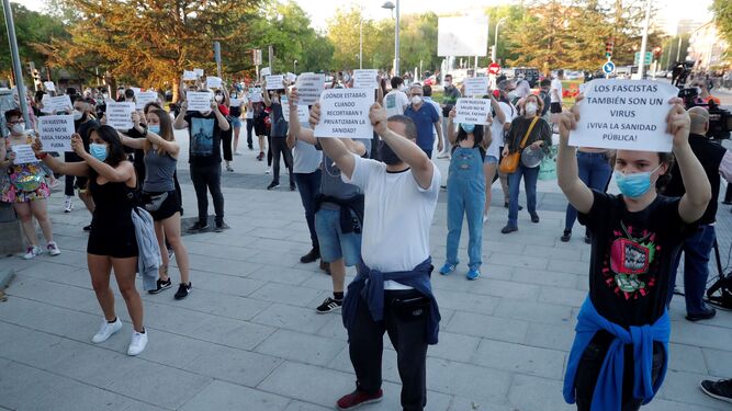Ciudadanos con mascarillas muestran carteles durante una concentración a favor de la Sanidad pública, este jueves en Madrid.