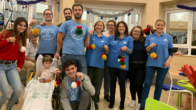 Voluntarios de La Caixa en su colaboración con Andex y los niños con cáncer ingresados en el Hospital Virgen del Rocío, antes de la pandemia.