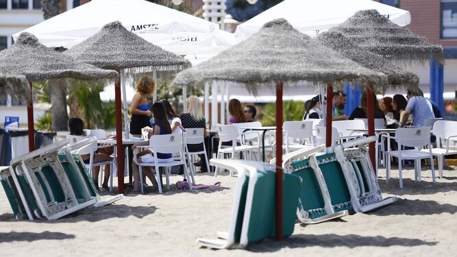 Algunas personas almuerzan en una playa de Málaga.