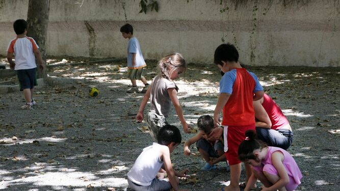 Alumnos jugando en el patio de un colegio durante los meses de verano.