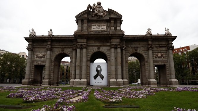 La madrileña Puerta de Alcalá, con un crespón negro por las víctimas del coronavirus.