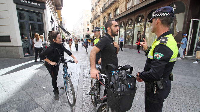 Agentes de Policía Local atienden a ciclistas en el centro de la Sevilla.