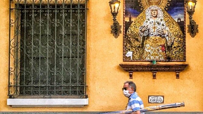 Un viandante pasa por delante del azulejo de la Virgen de la Esperanza