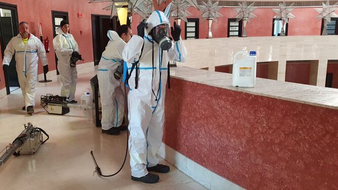 Operarios se preparan para desinfectar el Palacio de Congresos de Sevilla.