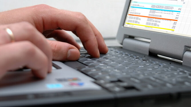 Un trabajador produce a distancia con un ordenador portátil.