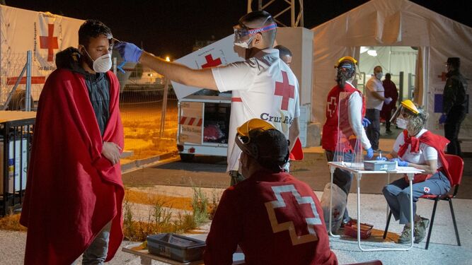 Voluntarios de la Cruz Roja efectúan controles a un grupo de inmigrantes argelinos que llegó al puerto de Motril a finales de mayo.