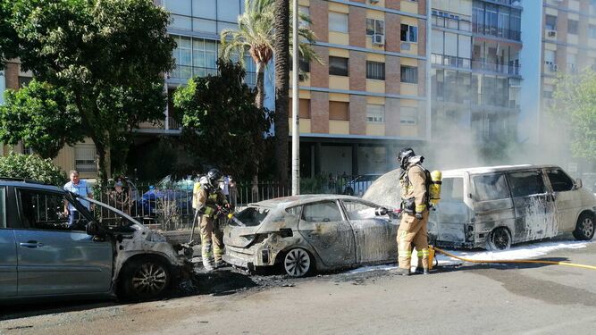 Los Bomberos apagan uno de los coches incendiados en Los Remedios el pasado jueves.