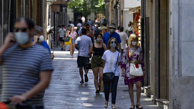 Gente con mascarillas por Granada.