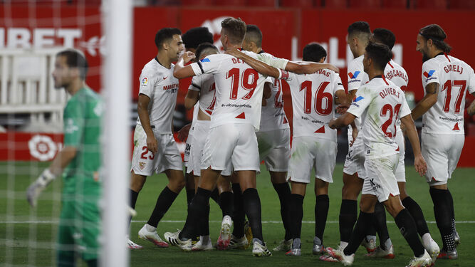 Los jugadores del Sevilla celebran en una piña el gol de Reguilón.