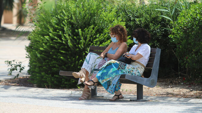 Dos mujeres con mascarilla en un banco en la Universidad de Almería.