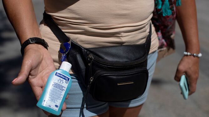 Una mujer muestra el gel en tamaño pequeño que porta en el bolso.