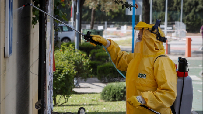 Un empleado municipal con traje protector desinfectando hoy las calles de Mairena del Aljarafe