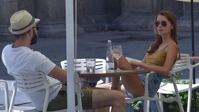 Una pareja en una terraza de Sevilla.