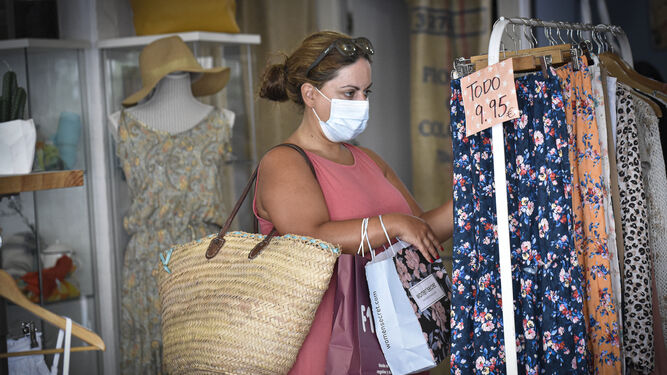 Una mujer mira ropa en una tienda de Los Remedios.