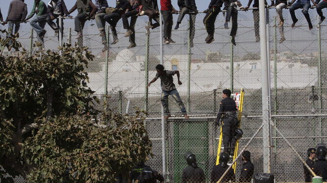 Varios inmigrantes subsaharianos encaramados a la valla  de  Melilla en una imagen de archivo.