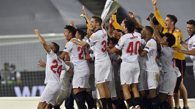 Los futbolistas sevillistas, eufóricos con la copa de campeones.