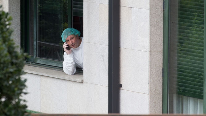 Un hombre con protección se asoma por la ventana de la residencia de O Incio, Galicia.