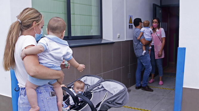 Los padres llevan a sus hijos a la guardería manteniendo la distancia de seguridad.
