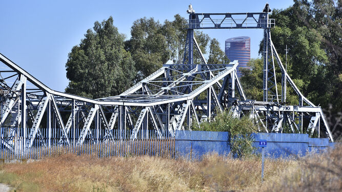 El Puente de Hierro  rodeado de maleza en la parcela del Puerto cercana al Parque del Guadaíra.
