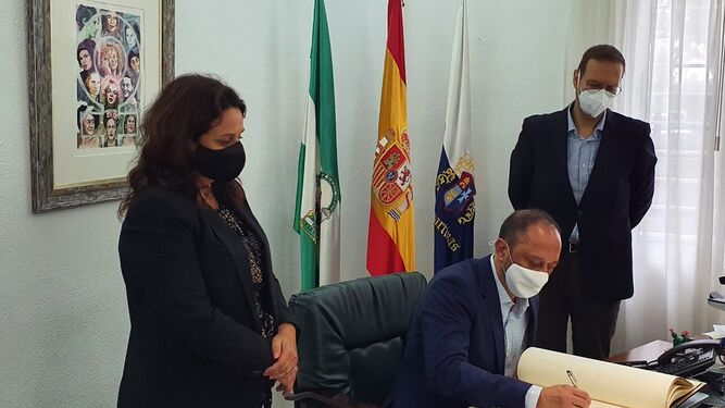 Alfonso Rodríguez Gómez de Celis, firmando en el Libro de Honor del Ayuntamiento de Espartinas, junto a la alcaldesa y el secretario.