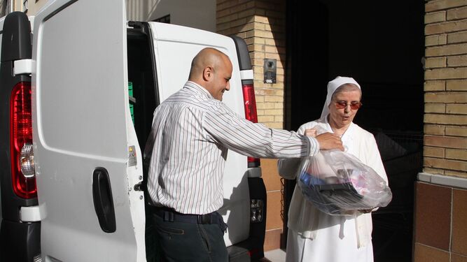 Una hermana de la Caridad recoge alimentos en la puerta de la residencia de ancianos del Pumarejo.
