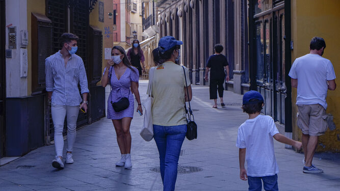 Ciudadanos con mascarilla por las calles de Sevilla.