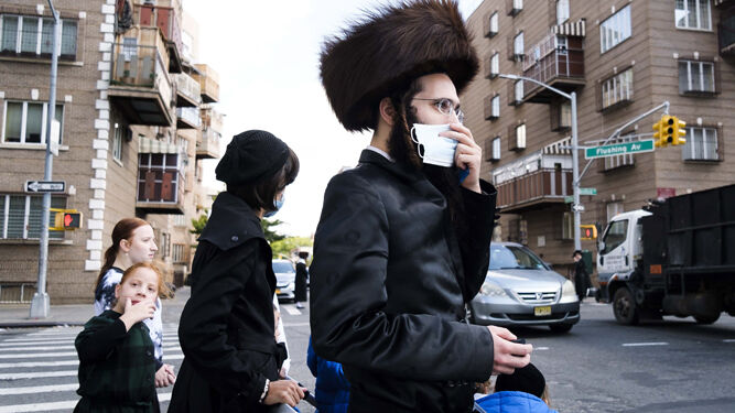 Una familia judía hasídica cruza una calle en Williamsburg, Brooklyn, una de las zonas de Nueva York más afectadas por el coronavirus.
