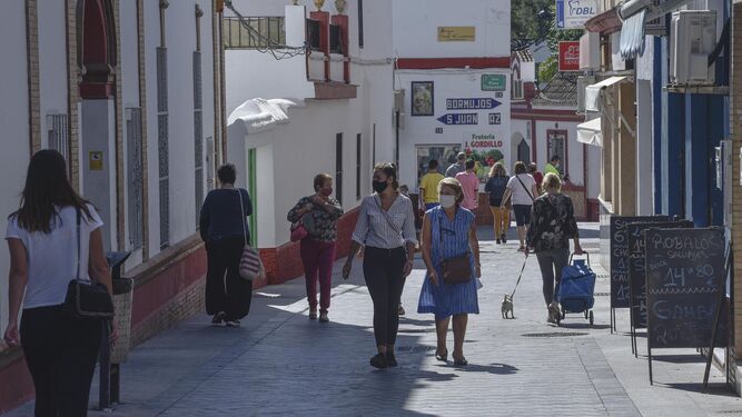 La céntrica calle Tomas Ybarra de Tomares, con sus carteles al fondo que indican las direcciones a Bormujos y San Juan.