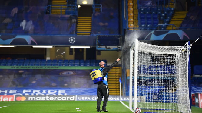 Un operario desinfecta una de las porterías de Stamford Bridge antes del partido.