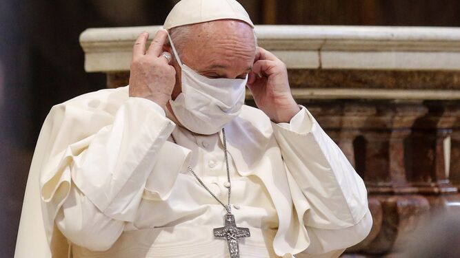 El papa Francisco se coloca una mascarilla durante un acto de oración