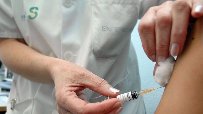 Una enfermera administra una vacuna.