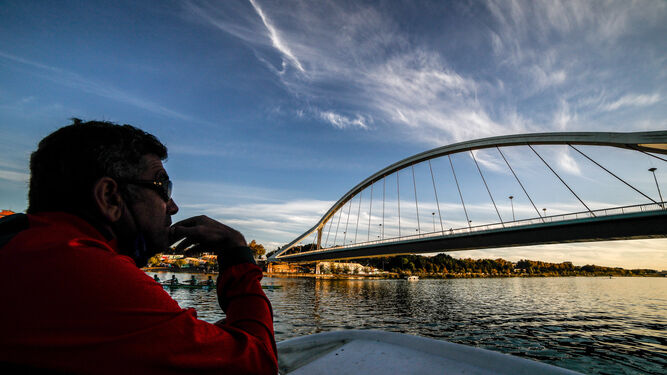 Un aficionado observa el paso del bote por el puente de La Barqueta.