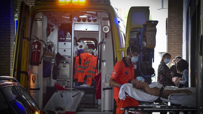Personal del servicio de emergencias sanitarias traslada a un enfermo en camilla a las Urgencias del Virgen Macarena.