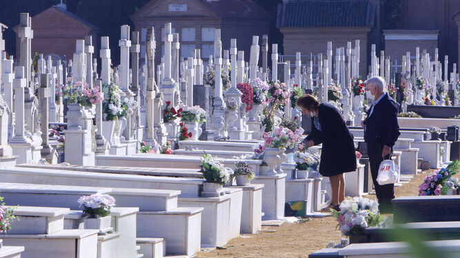 Dos personas durante la visita a la tumba de algún familiar durante el pasado fin de semana.