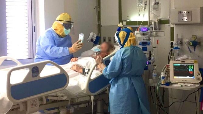 Dos profesionales sanitarias atienen a un paciente en la UCI.
