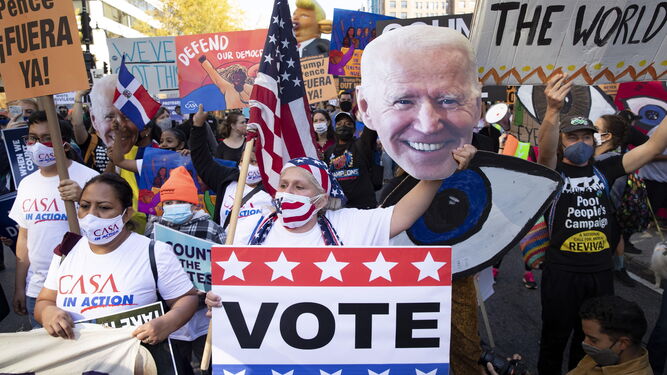 Varias personas piden el voto para Biden