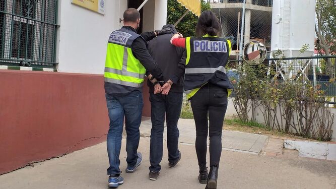Dos policías nacionales trasladan al detenido a la comisaría del distrito Nervión.