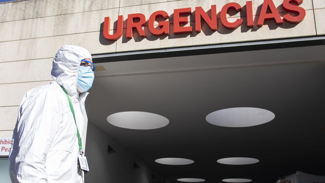 Un sanitario ante la entrada de Urgencias de un hospital